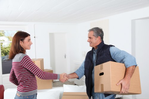 Professional movers loading home contents with protective wrapping